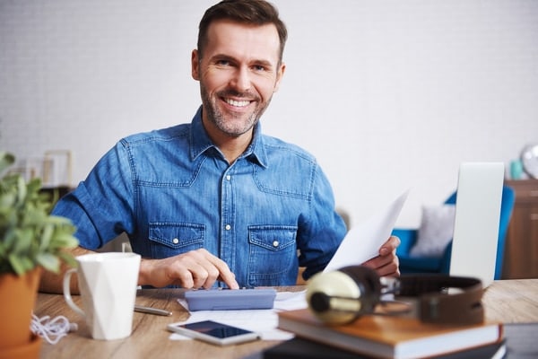 A smiling man calculating his scores